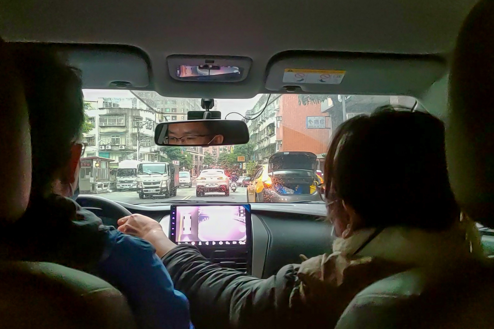 道路駕駛課程教學汽車臨停狀況，等待對向車道無來車，方向盤往左打閃過臨停車輛緩緩前進，輪胎稍壓黃線沒有關係，以順利通過